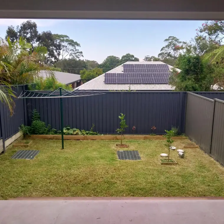 The same backyard mown into a neat, even striped lawn